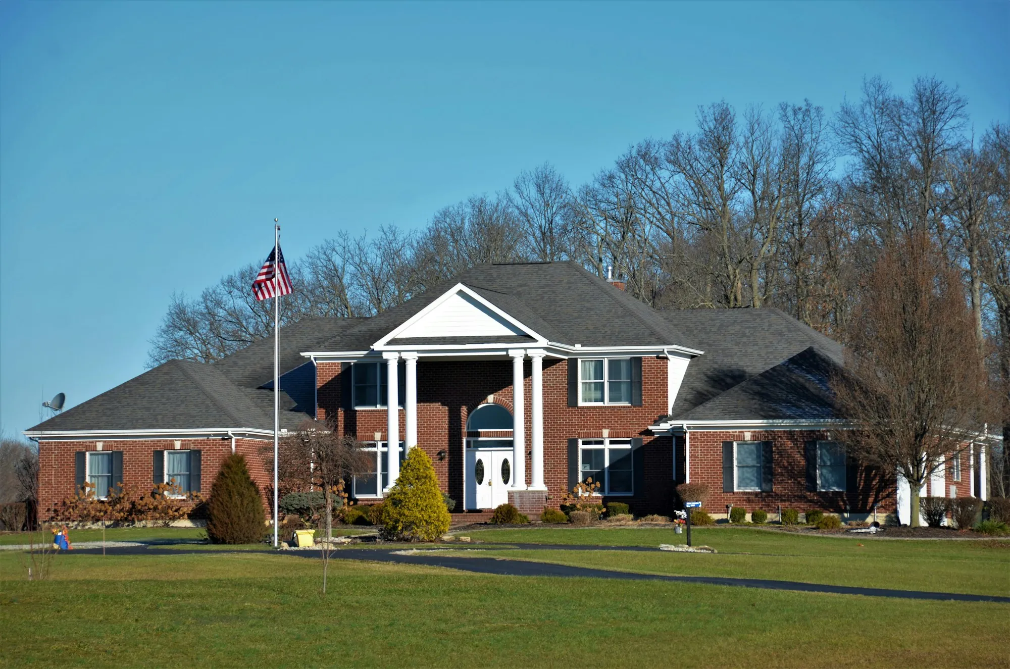 Brick home with a white columned entry and an American flag