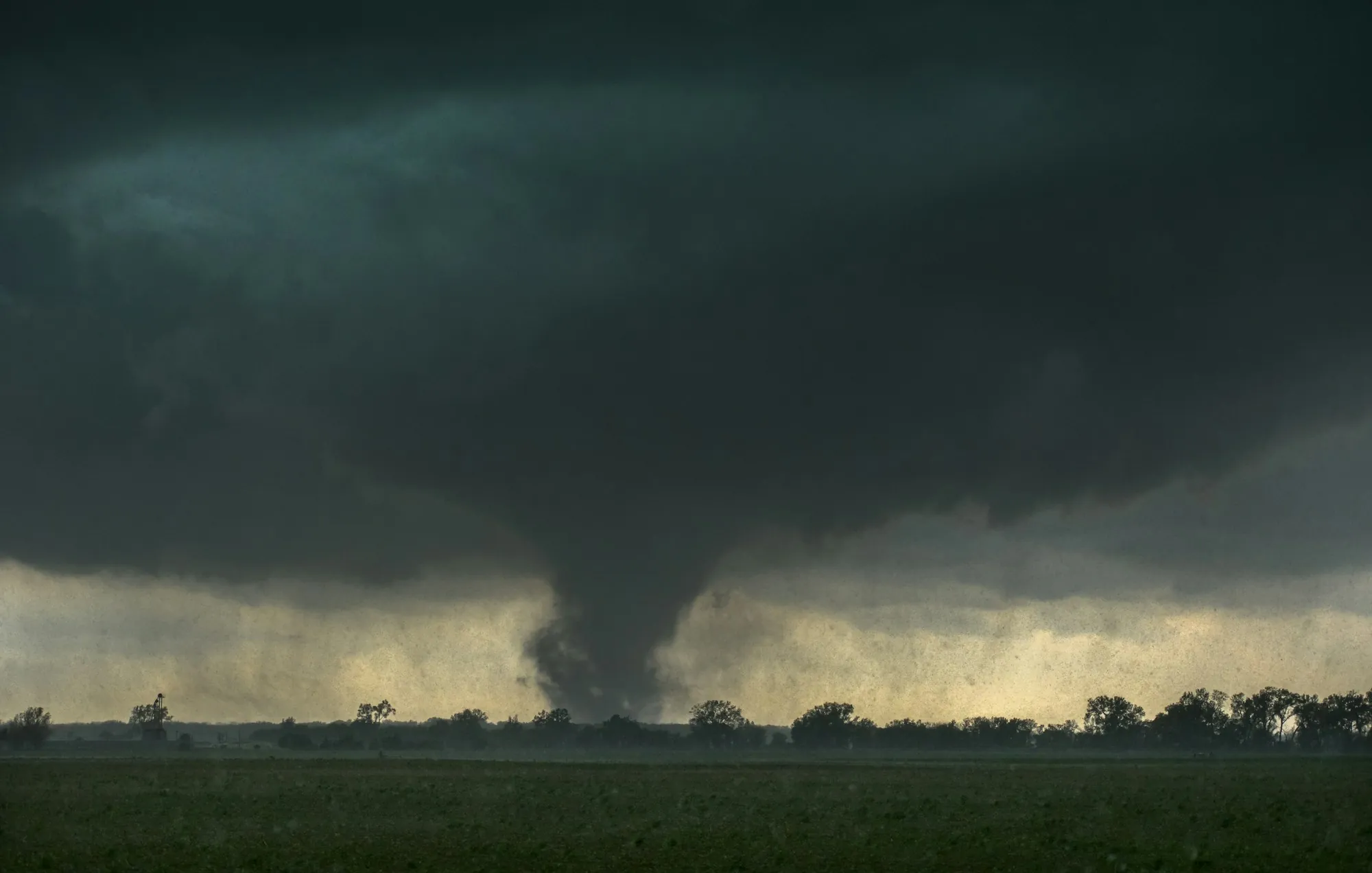 Tornado touching down over flat farmland